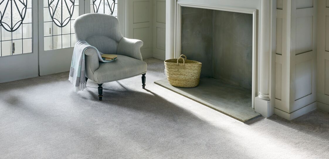 A living space with small armchair in front of a fireplace.