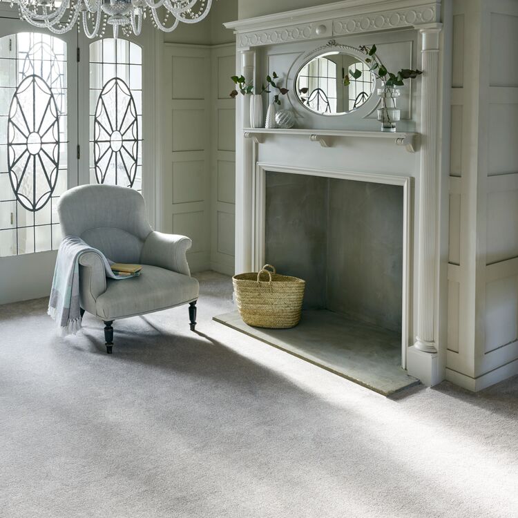 A living space with small armchair in front of a fireplace.